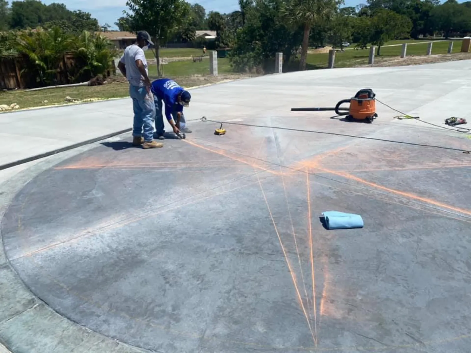 Crew laying out a hand-carved compass star on a concrete driveway in Brevard County