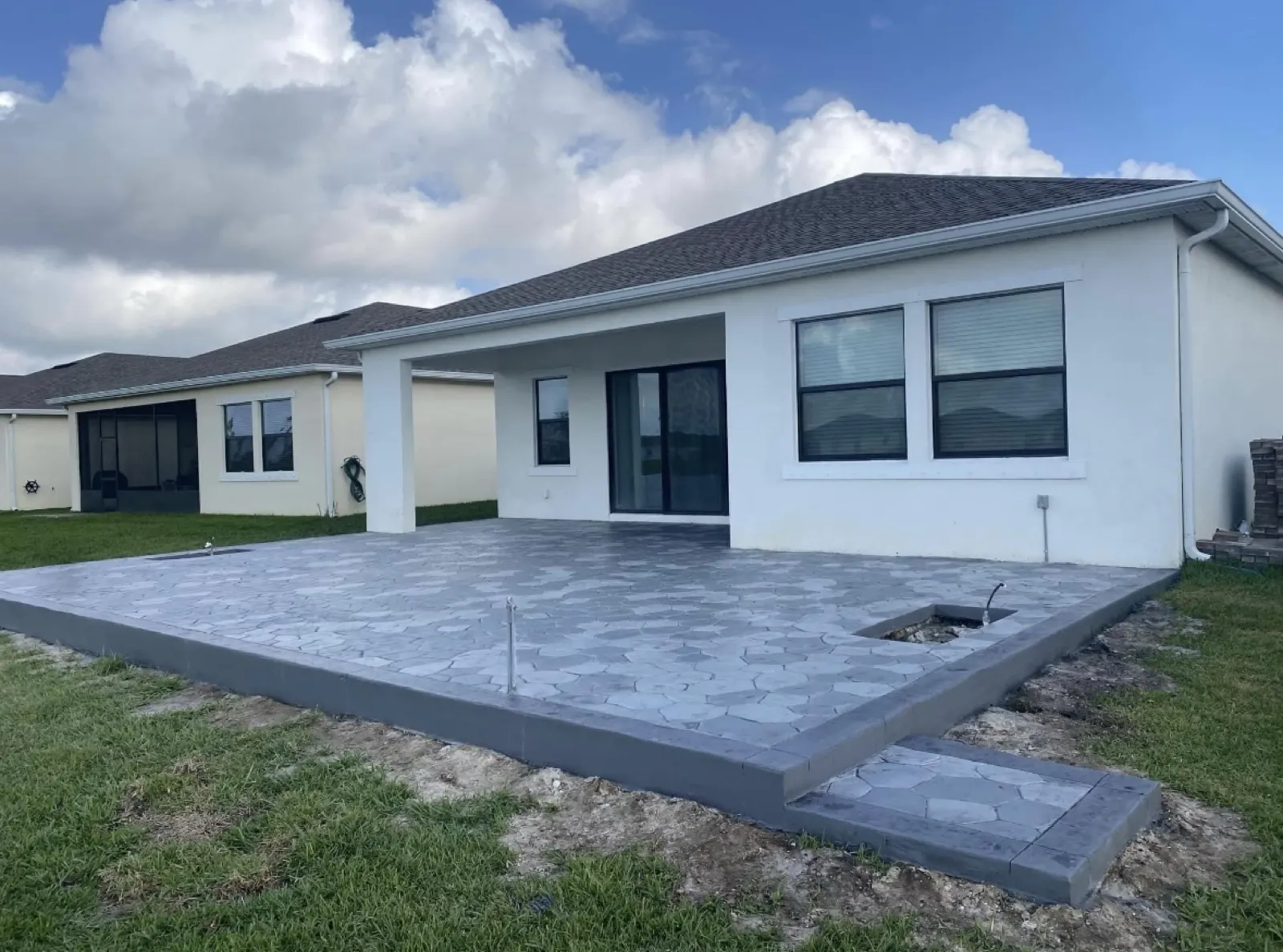 Gray broom finished concrete slab poured behind a home