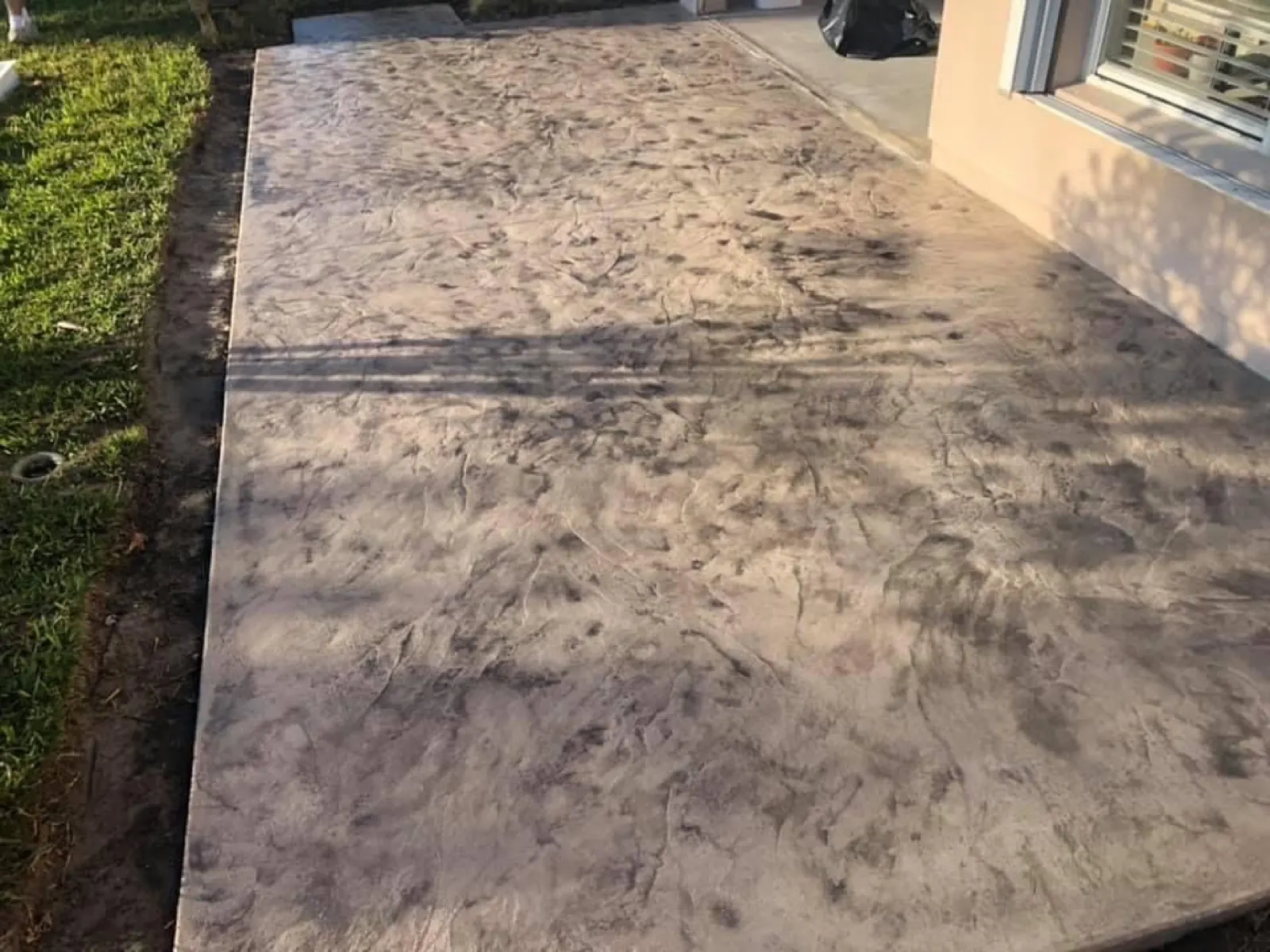Seamless texture stamped concrete walk along the side of a home