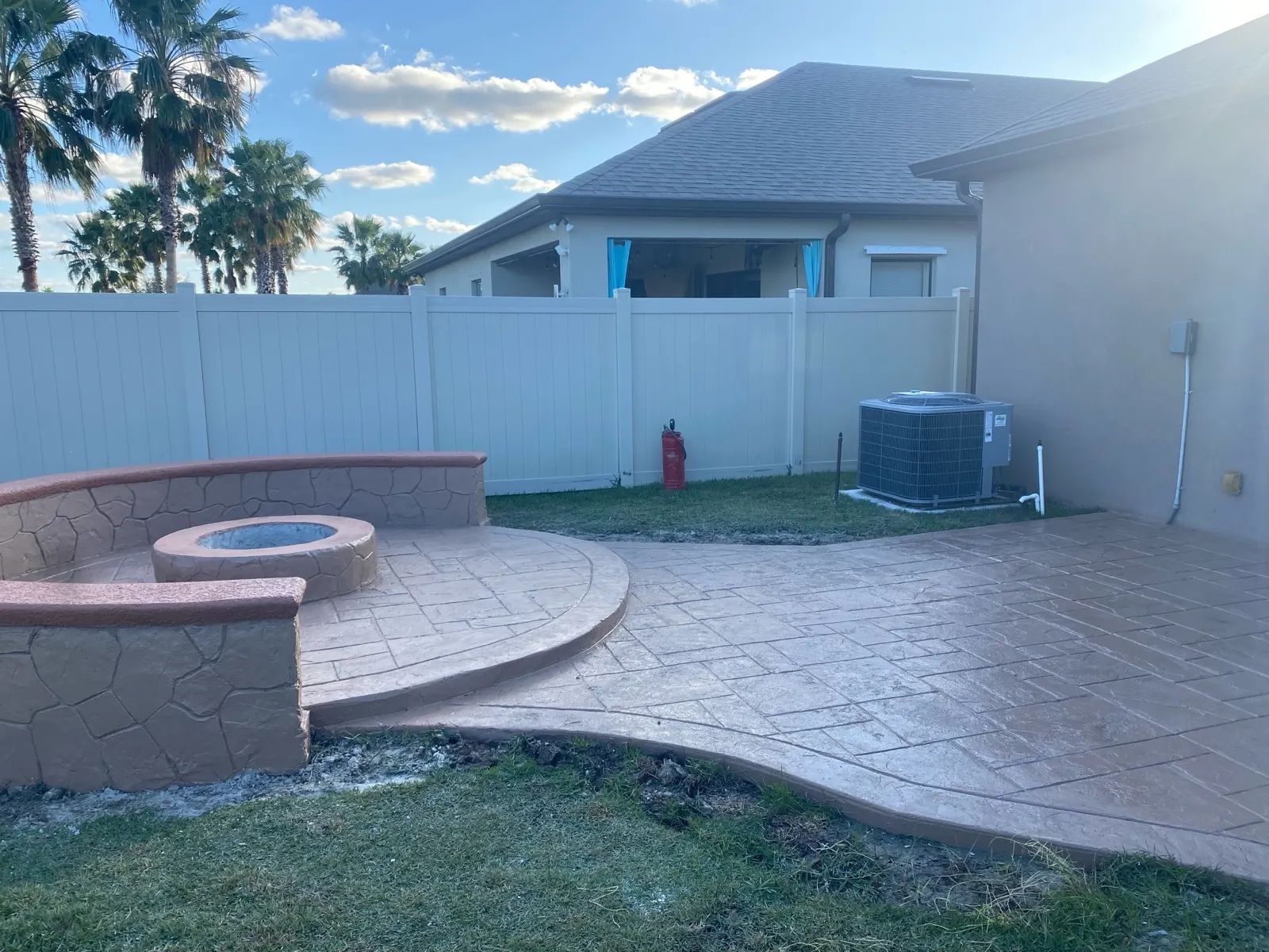 Stamped concrete patio with a curved seat wall and a fire pit