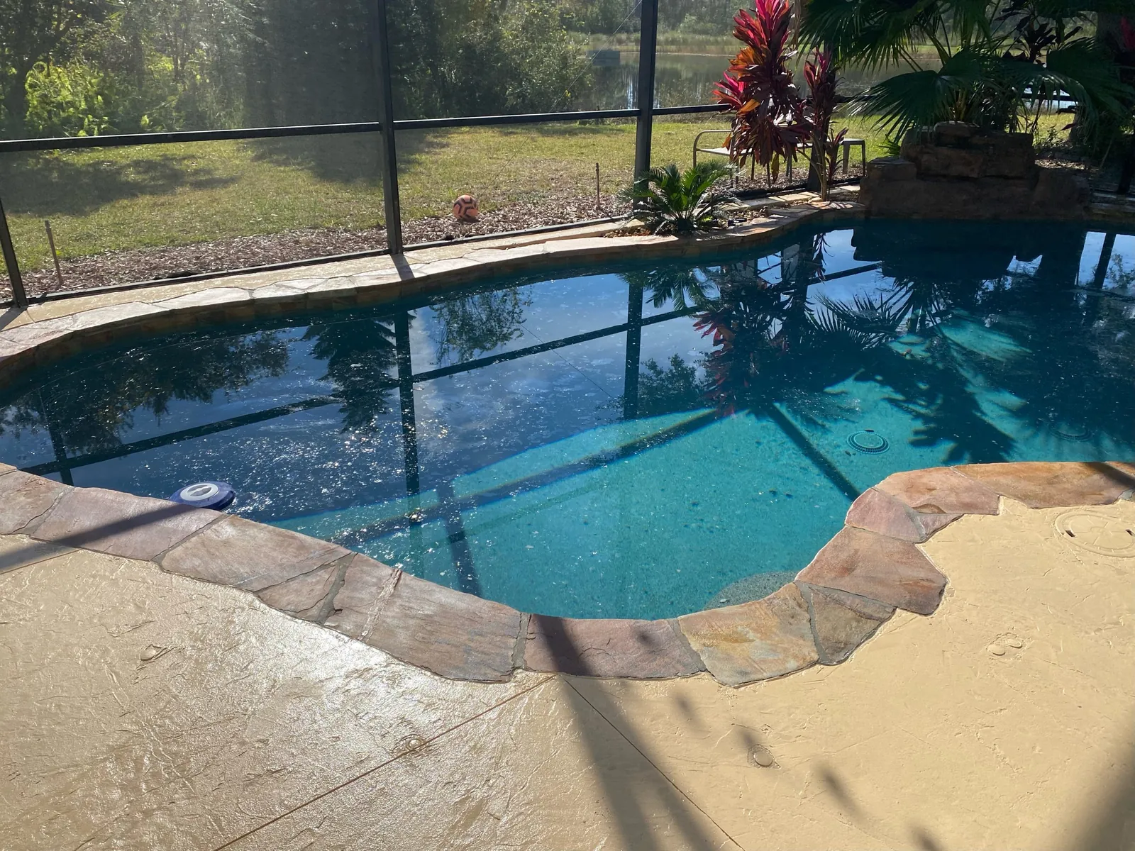 Stone look coping edge around a screened pool in Brevard County