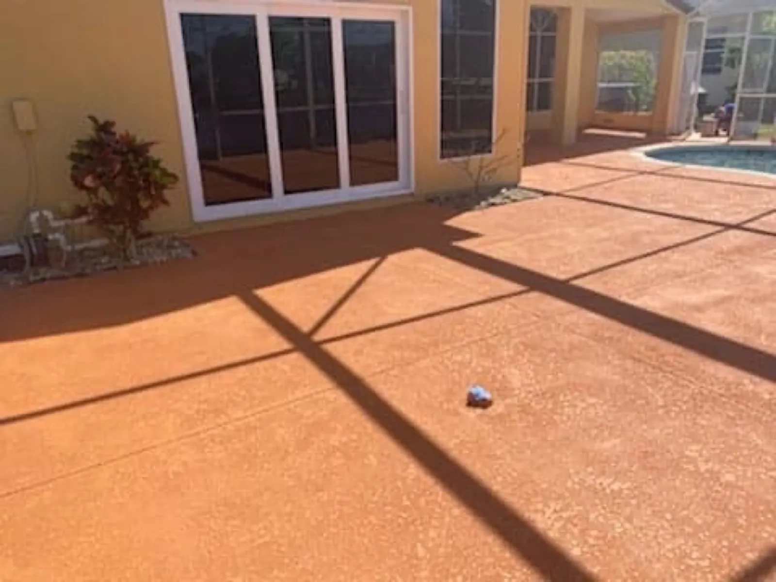 Terracotta knockdown texture coating on a screened pool deck