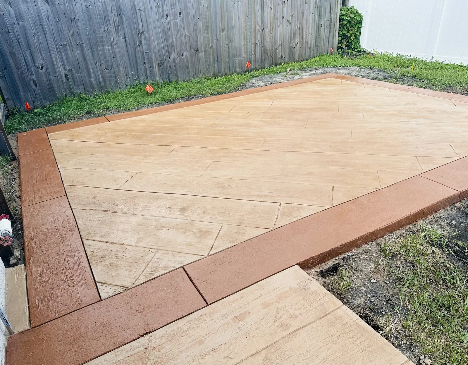 Wood plank stamped concrete patio with a terracotta border